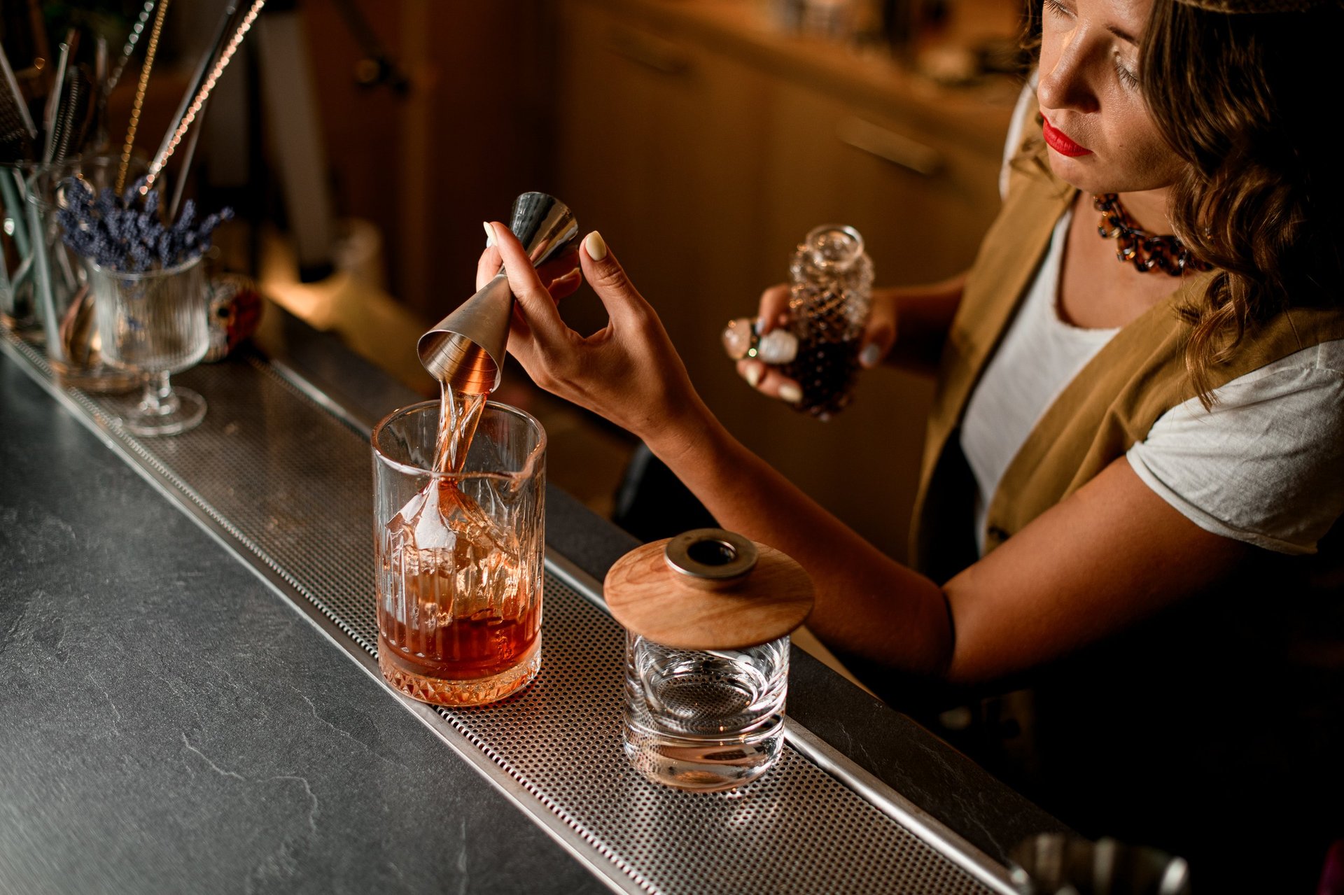Female bartender pouring drink at bar counter