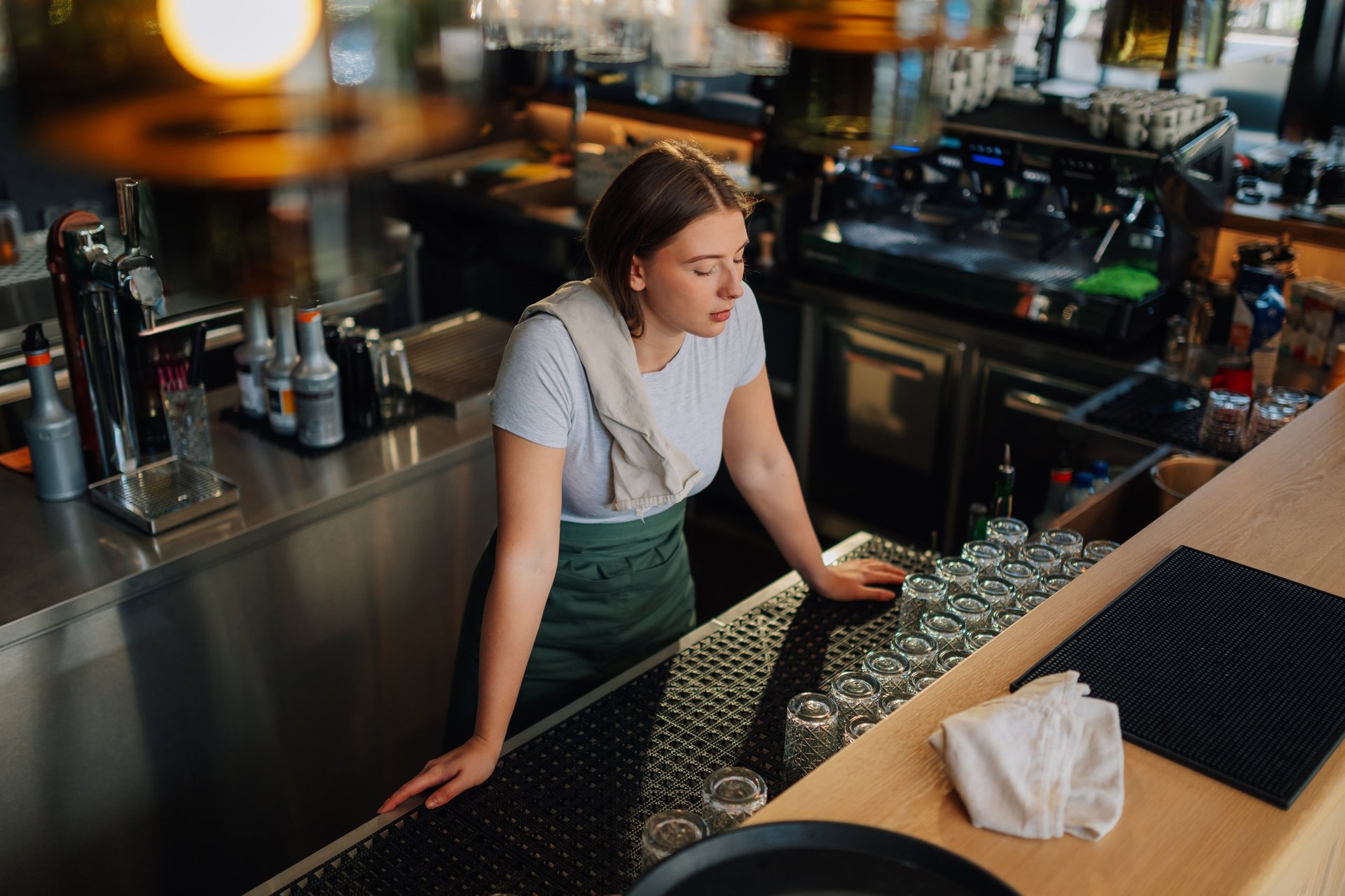 Female bartender serving customer at restaurant bar